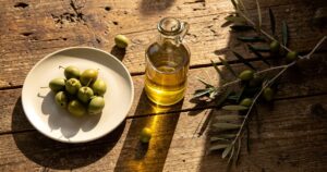 Bouteille d'huile d'olive extra vierge sur une table en bois avec des olives fraîches